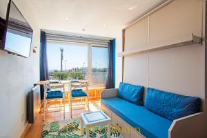 a living room with a blue couch and a table at L'écume bleue du Saint-Maurice in Sète