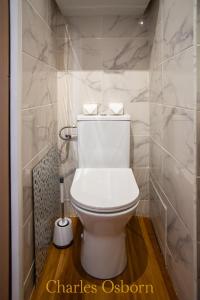 a white toilet in a bathroom with marble walls at L'écume bleue du Saint-Maurice in Sète +9 photos