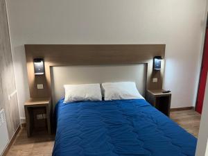 a bedroom with a blue bed with two night stands at ClassEco Gent in Ghent