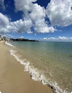 a beach with the ocean and a cloudy sky at Linda kitnet mobiliada 05 in Salvador