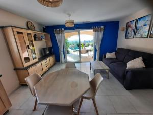una sala de estar con una mesa y un sofá en Logement indépendant C & D, en Lorgues