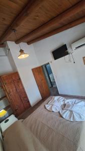 a bedroom with a bed and a tv on the wall at Complejo NONA RITA in Villa Cura Brochero