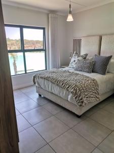 a bedroom with a bed and a large window at The Blyde Crystal Lagoon - 3 Bedrooms with Lagoon Views in Pretoria