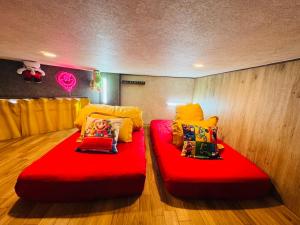 two red beds sitting on the floor in a room at Hotel Emiru 敷地内駐車場2台 in Osaka