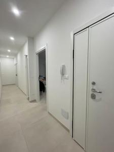 un corridoio con pareti bianche e una porta di vetro di Turris Apartments, SKYLINE historic center Bologna a Bologna