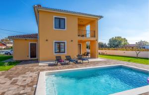 a villa with a swimming pool in front of a house at Lovely Home In Gajana in Gajana