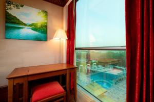 a room with a desk and a window with a fish tank at Holiday Inn Kuwait Al Thuraya City by IHG in Kuwait