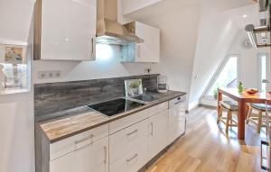 プラウ・アム・ゼーにあるFerienwohnung Plau Am Seeの白いキャビネットと木製のカウンタートップを備えたキッチン