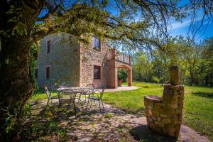 stół i krzesła przed budynkiem w obiekcie Agriturismo Fattoria Walden w mieście Ficulle