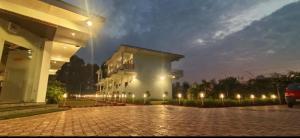 un edificio illuminato con luci su una strada di mattoni di Kuyal Corbett Resort a Ramnagar