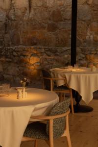 two tables in a restaurant with white table cloth at La Casa del Presidente Small Luxury Hotels in Ávila