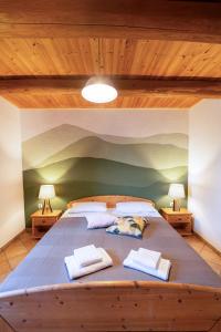 duże łóżko w pokoju z drewnianymi sufitami w obiekcie Agriturismo Fattoria Walden w mieście Ficulle