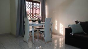 un soggiorno con tavolo da pranzo e sedie di Dawhenya Bungalow 2 a Tema