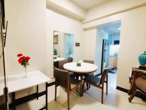 a room with a table and chairs and a mirror at Mactan Newtown Cebu Affordable Suite! in Mactan
