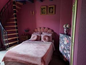 sypialnia z łóżkiem z różową ścianą w obiekcie BOIS DE CHENES HOUSE w mieście Phalsbourg