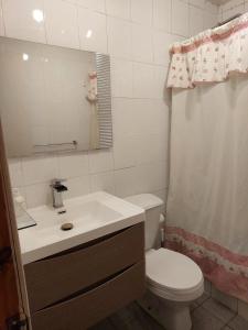 a bathroom with a toilet and a sink and a mirror at Casa cerro Tacna Maitencillo in Maitencillo