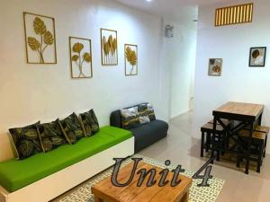 KawitFACE Transient Rooms的客厅里有一张绿色的沙发和一张桌子