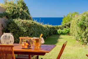 a wooden table with a bowl of fruit on it at Villa Lumière in Costa Paradiso
