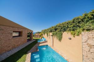 a swimming pool in the backyard of a house at Villa Lumière in Costa Paradiso