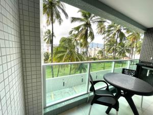 een balkon met een tafel en stoelen en palmbomen bij RN Studio Premium 103 Vista Mar in Maceió