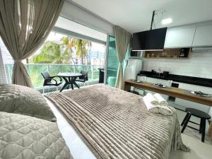 een slaapkamer met een bed en een keuken met een raam bij RN Studio Premium 103 Vista Mar in Maceió