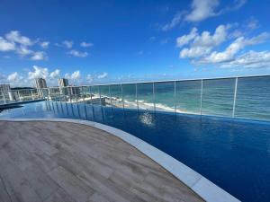 een zwembad met de oceaan op de achtergrond bij RN Studio Premium 103 Vista Mar in Maceió