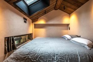 a bedroom with a large bed with a skylight at Le Grenier sur l'Eau -5 étoiles- Saint-Malo in Saint Malo