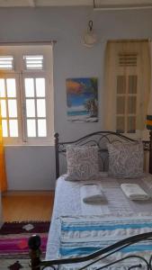 ein Schlafzimmer mit einem Bett mit weißen Laken und Kissen in der Unterkunft Maison charmante à Saint-Pierre avec parking et Wi-Fi. in Saint-Pierre