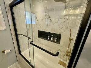 a bathroom with a shower with a glass door at Parma Ranch with Hot Tub and Game and Media Room in Parma +72 photos