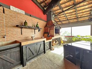 eine Küche mit einer Theke und einer Ziegelwand in der Unterkunft Refugio Jardim Prazeres WiFi BBQ in Prazeres