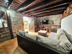 ein Wohnzimmer mit Sofa und Fernseher in der Unterkunft Refugio Jardim Prazeres WiFi BBQ in Prazeres