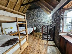 ein Schlafzimmer mit zwei Etagenbetten und einem Fenster in der Unterkunft Refugio Jardim Prazeres WiFi BBQ in Prazeres