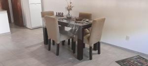 a dining room table with chairs and a vase on it at MG in San Carlos de Bolívar