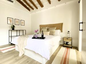 a white bedroom with a large bed with a tray on it at Historic House at Can Quintana by Casa de Elena in Pineda de Mar