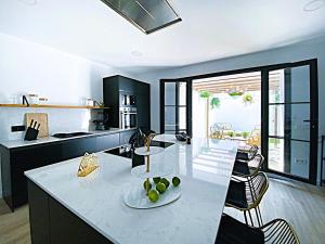 a kitchen with a counter with a table and chairs at Historic House at Can Quintana by Casa de Elena in Pineda de Mar +56 photos