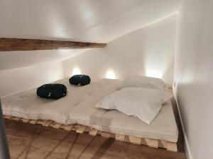 a bed with two bags sitting on top of it at Le gîte du Verger - Appartement à Arc et Senans in Arc-et-Senans