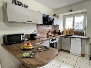a kitchen with a table with a plate of fruit on it at La GALERIE in Onet le Château +10 photos