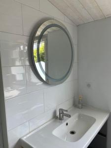 a white bathroom with a sink and a mirror at Maison située à 150m de la plage de la Madeleine in Noirmoutier-en-l'lle