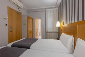 Postel nebo postele na pokoji v ubytování Hotel Lyon