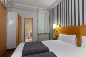 Postel nebo postele na pokoji v ubytování Hotel Lyon