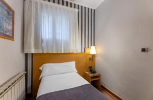 Postel nebo postele na pokoji v ubytování Hotel Lyon