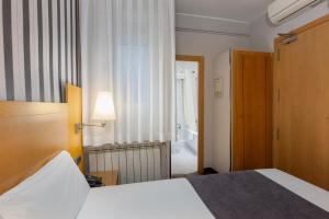Postel nebo postele na pokoji v ubytování Hotel Lyon