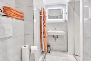 a white bathroom with a sink and a toilet at JAKSE-Apartments - Urban Jungle - top Lage & flexibler Checkin in Bochum +33 photos