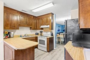 a kitchen with wooden cabinets and a white stove top oven at Dry Dock 101 in Myrtle Beach