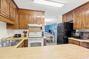 a kitchen with wooden cabinets and a black refrigerator at Dry Dock 101 in Myrtle Beach