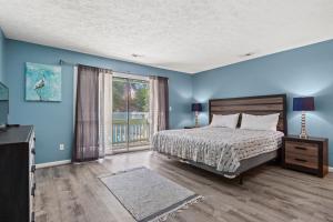 a bedroom with blue walls and a bed and a window at Dry Dock 101 in Myrtle Beach +23 photos