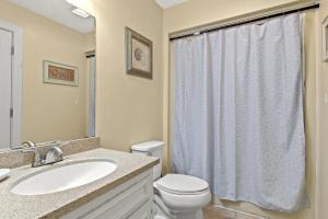 a bathroom with a white toilet and a sink at Dry Dock 101 in Myrtle Beach