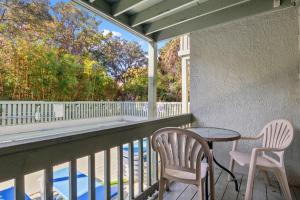 a balcony with a table and chairs and a pool at Dry Dock 101 in Myrtle Beach