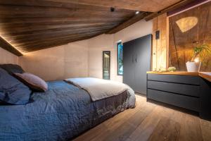 sypialnia z łóżkiem i drewnianym sufitem w obiekcie La Grange aux Hirondelles -5 étoiles- Saint-Malo w Saint-Malo