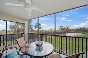 a balcony with a glass table and chairs at Sandpiper Beach 101 in Sanibel